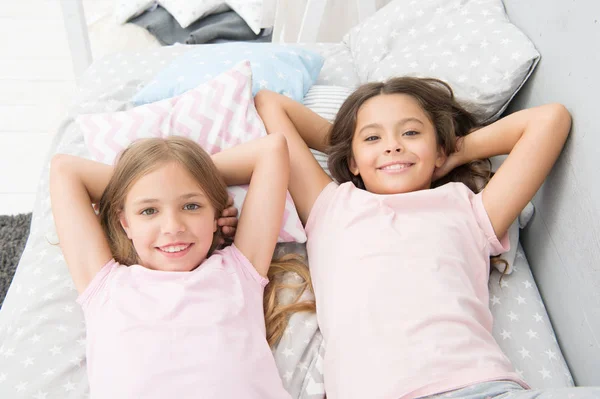 Being as happy as the day is long. Happy little girls having afternoon nap in bedroom. Adorable small children relaxing on bed. Enjoying happy childhood. Carefree and happy — Stock Photo, Image