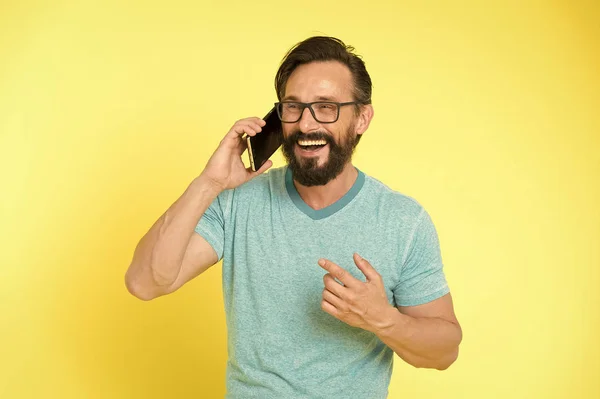 Blijf in contact. Man met baard vrolijke volwassen man houd mobiele telefoon gele achtergrond. Hipster smartphone gesprekspartner. Man mobiel bellen smartphone. Mobiel bellen concept. Belangrijk mobiele gesprek — Stockfoto