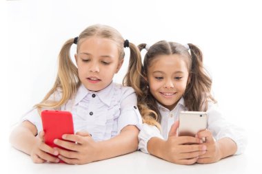 Zeki öğrenciler. Küçük öğrencilerin ders sırasında mesaj atması beyaza izole edilmiş. Akıllı telefon derslerine dalan tatlı lyceum öğrencileri. Sınıfta cep telefonu kullanan küçük öğrenciler