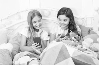 Noel zamanında Noeller dilemek için en iyi yol. Küçük kız yatakta smartphone kullanın. Cep telefonu ile mutlu küçük çocuklar. Telefonla manifatura Noel ve yeni yıl tebrik. Yeni Yılınız Kutlu Olsun