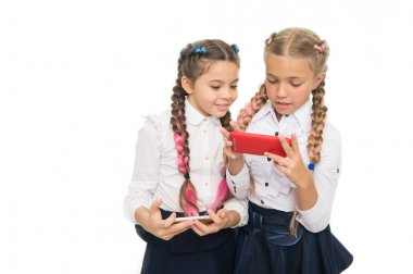 Gelecek burada. Küçük kız öğrenciler beyaz izole akıllı telefonlar kullanarak. Küçük çocuklar gelecekteki yaşam için mobil teknolojileri öğreniyorlar. Dijital becerilerle gelecek kariyeri. Eğitimin geleceği, kopya alanı