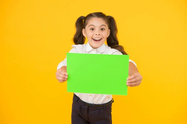 Prochain événement. Regarde là. L'uniforme de l'école des filles tient affiche. Retour à l'école. Affiche d'écolière. Écolière tenir affiche copie espace. Nouvelles promotion de l'information. Changements à venir — Photo