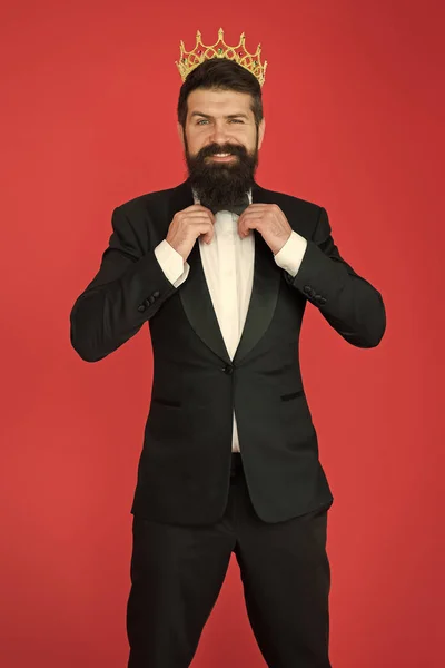 Bearded man in tuxedo and bow tie. Big boss. Formal event. King crown. Man groom in wedding suit. Egoist. Businessman in tailored tuxedo and crown. Formal tuxedo wear male fashion. Happy tuxedo man