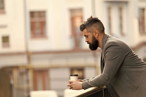 City lifestyle. Businessman well groomed appearance enjoy coffee break out of business center urban background. Relax and recharge. Man bearded hipster drink coffee paper cup. One more sip of coffee — Stock Photo, Image
