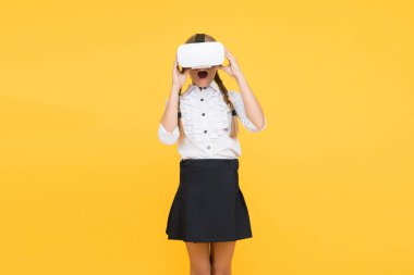 Yeni gerçekliğin tadını çıkar. Mutlu çocuk modern teknoloji kullanıyor. Gelecekteki eğitim. Okula dönüyorum. Dijital gelecek ve yenilik. Sanal gerçeklik. VR kulaklıklı küçük kız. Küçük çocuk kablosuz VR gözlük takıyor