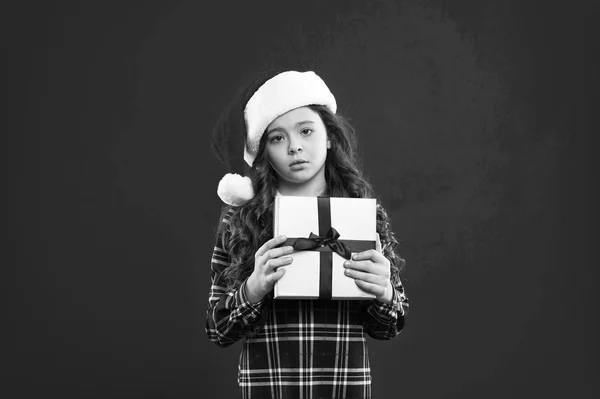 Festa de Ano Novo. Miúdo do Pai Natal. Compras de Natal. Presente para o Natal. Infância. Criança no chapéu vermelho do Pai Natal. Boas férias de inverno. Pequena rapariga séria. Feliz Natal e Boas Festas — Fotografia de Stock