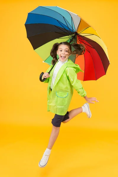 Je mi to fuk. Neopatrná školka skákající s deštníkem bez vodotěsných pláštěnky. Podzimní déšť. Deštivé dny světlé příslušenství. Déšť není tak špatný, když máš na vodě odolné oblečení. Jednoduché štěstí — Stock fotografie