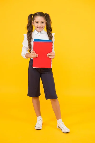 A tudás fény. Imádnivaló kislány kezében könyv sárga háttérrel. Aranyos kisgyerek, iskolai tudással a kezében. Tudásnap vagy szeptember 1. A tudás és készségek megszerzése — Stock Fotó