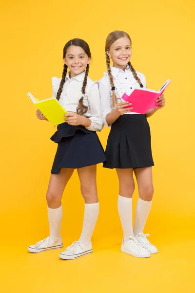 Dia do conhecimento. Dia da escola. Amizade escolar. Menina com livros de cópia ou cadernos. Estudar juntos. Crianças estudantes bonitos. Estudantes melhores amigos excelentes alunos. As alunas usam uniforme escolar — Fotografia de Stock