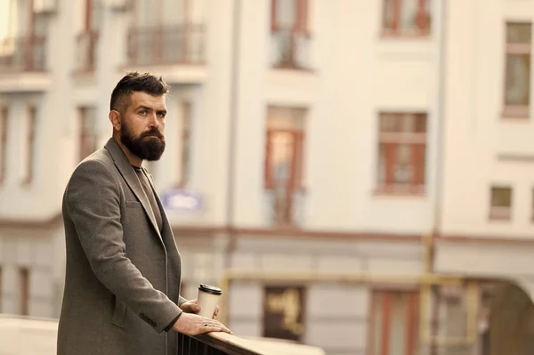 Man bearded hipster drinking coffee paper cup. One more sip of coffee. Enjoying coffee on the go. Businessman well groomed appearance enjoy coffee break out of business center. Relax and recharge — Stock Photo, Image