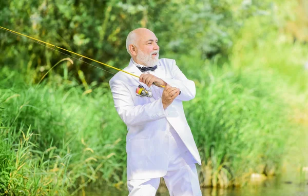 Hombre de negocios retirado. Elegante hombre barbudo pescando. Concepto de vida de lujo. Abuelo es mi nombre, pescar es mi juego. Hobby y recreación. Pescador de traje formal. Atrapar con éxito. Hombre mayor de pesca —  Fotos de Stock