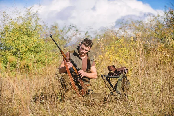 Man with rifle hunting equipment nature background. Recharge rifle concept. Hunting equipment and safety measures. Prepare for hunting. What you should have while hunting nature environment