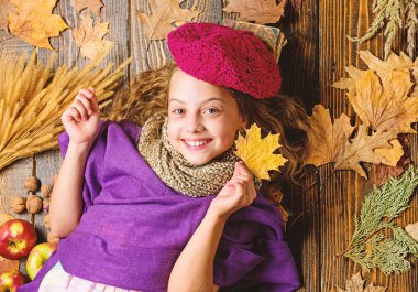 Örme şapka trend sonbahar sezonu. Kız yatıyordu ahşap arka plan yaprakları yukarıdan düşmüş. Aksesuar moda ayrıntı ördü. Çocuk kız parlak yumuşak örme şapka bere. Sonbahar moda örgü aksesuar