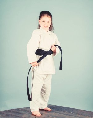 Aktivite ve spor. Karate güven hissi verir. Güçlü ve güvenilir bir çocuk. Beyaz kimono, kemer ile küçük kız çocuk. Karate savaşçısı savaşmaya hazır. Karate spor konsepti. Self savunma becerileri