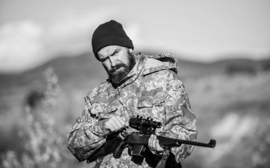 Hunter tüfek tutun. Odak ve deneyimli avcı konsantrasyonu. Avcılık ve bindirme mevsimleri. Erkeksi hobi avcılık. Adam acımasız bekçi doğa arka plan. Sakallı avcı eğlence avcılık harcamak