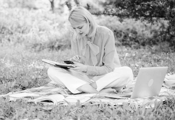 成为成功的自由职业者。拿着笔记本电脑的女人坐在地毯草地上。女孩与记事本写笔记。自由职业者的职业理念。指导开始自由职业者的职业生涯。商务女士自由职业者的工作户外 — 图库照片