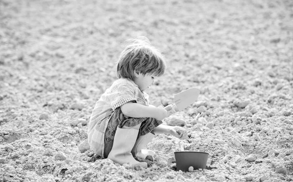 Niño jardinero feliz. trabajador botánico. Temporada de primavera. salud y ecología. Día de la Tierra. nueva vida. granja de verano. la vida ecológica. eco granja. humano y la naturaleza. Un niño pequeño plantando una flor. lugar de trabajo —  Fotos de Stock