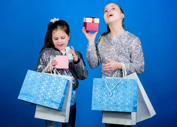 Minden termék kézbesítve Önnek. Vásárlás és vásárlás. Fekete péntek. Eladás és kedvezmény. Bevásárló-nap. Gyermek csomó csomagokat. Gyerekek divat. Lányok nővérek barátok bevásárló táskák kék háttér — Stock Fotó