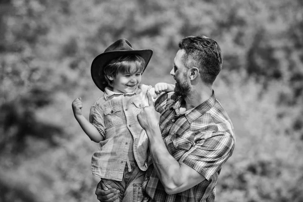 Szellemében kalandok. Erős, mint apa. Hatalom, hogy apja. Gyermek szórakozik cowboy apa. Rusztikus család. Növekvő aranyos cowboy. Kis segítőnk a kertben. Kisfiú és apa a természetben háttér — Stock Fotó