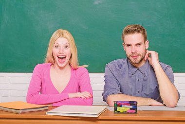 Ücretsiz program uygulanır. Kaç arkadaş üniversite okuyan öğrenciler. Üniversite hayatının tadını çıkarıyor. Adam ve kız sınıfta masada otur. Doğru cevap onların aklında. Kolej veya üniversite eğitimi