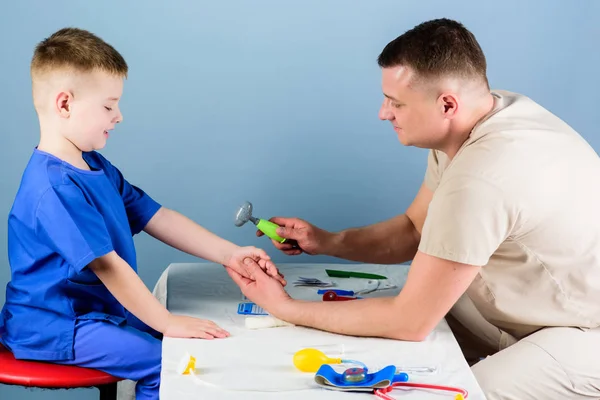 Medicina y salud. niño feliz con padre con estetoscopio. Un niño pequeño con papá jugando. pediatra. padre e hijo en uniforme médico. Asistente de laboratorio de enfermería. médico de familia. Padre y bebé — Foto de Stock