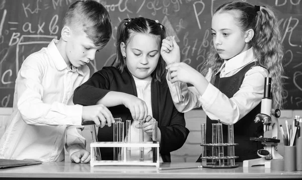 Kleine kinderen die scheikunde leren in het schoollab. studenten doen biologie experimenten met microscoop. Dag van de kinderen. Scheikunde. Terug naar school. Kleine kinderen op school. Zelfverzekerde apotheker — Stockfoto