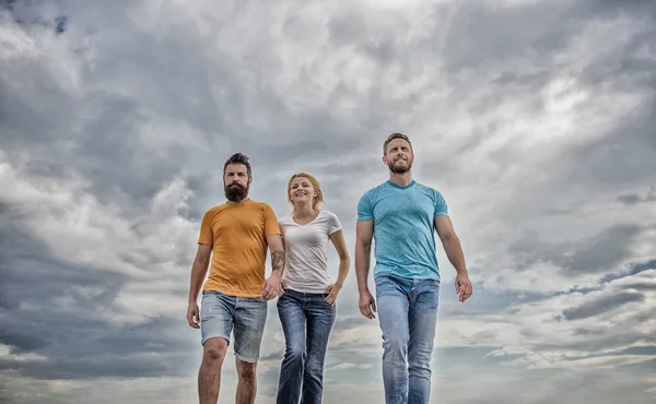 United threesome true friends. Men and woman walks dramatic cloudy sky background. True friendship grow with destiny obstacles. United group purposefully moves forward. Friendship tested for years — Stock Photo, Image
