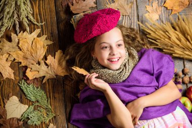 Kız ahşap arka plan düşmüş akçaağaç yaprakları üst görünümü yatıyordu. Şapka aksesuar moda detay. Çocuk kız parlak yumuşak örme şapka sonbahar tadını çıkarın. Sonbahar moda şapka aksesuarı. Moda trendi sonbahar sezonu