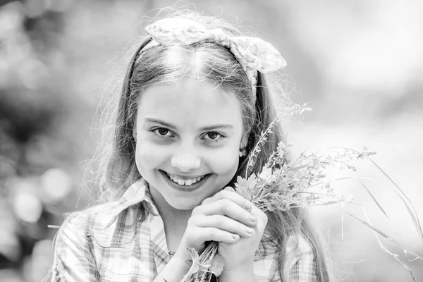 Glückliches Kind halten Wildblumen. natürliche Schönheit. Kinderglück. Sommerferien. grüne Umwelt. kleines Mädchen und Blumenstrauß. Wildblumen. Frühlingsferien. Frauentag. ewig jung und frei — Stockfoto