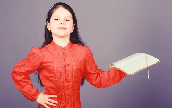 La bibliothèque est le temple de l'apprentissage. Petit enfant confiant tenant un livre de bibliothèque. Adorable petit lecteur de bibliothèque avec livre ouvert. Lecture dans une bibliothèque scolaire, espace de copie — Photo