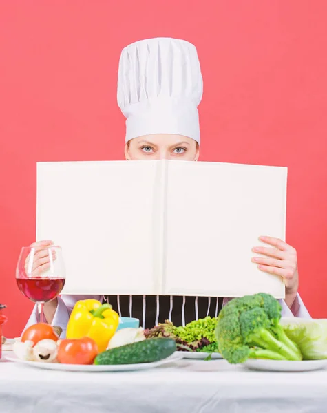 Boka varje hemmafrus behov i deras bibliotek. Söt kvinna läser kokbok i köket. Köksbiträde lär sig nya rätter från receptboken. Lady kock söker recept i kokbok, kopiera utrymme — Stockfoto