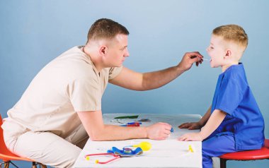 Tıbbi hizmet. Adam doktor küçük çocuk hasta muayene masa tıbbi araçları oturup. Sağlık. Çocuk doktoru kavramı. Çocuk bakımı. Dikkatli bir çocuk doktoru çocuğun sağlığını kontrol edin. Tıbbi muayene