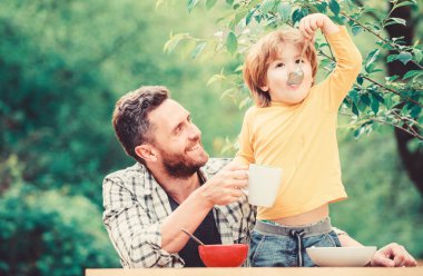 sağlıklı gıda ve diyet. Süt ürünleri. Sabah kahvaltısı. Vejetaryen diyeti. baba ve oğul yiyor. Babalar günün kutlu olsun. Babası olan küçük çocuk mısır gevreği yiyor. aile yemeği zamanı. Aile ile vakit geçirmek