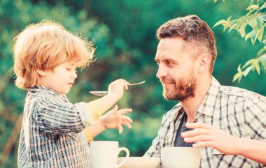 Oğlu katılarla besle. Babam ve çocuk dışarıda yemek yiyip beslerler. Sağlıklı beslenme alışkanlıkları geliştirmenin yolları. Bebeğini besle. Doğal beslenme kavramı. Oğlu doğal gıdalar besleme. Gelişim aşaması
