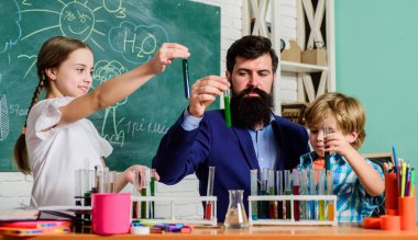 Çocuklar bilim gibi kulüp alanında büyüyebilir. Okul kulübü eğitimi. Öğretmen ve öğrenciler sınıfta test tüpleri. Kimya temalı kulüp. Maddelerin özelliklerini birlikte keşfedin ve keşfedin