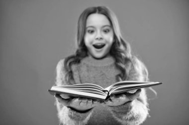 Çocuk kitap okuma keyfini çıkarın. Kitap mağaza konsepti. Harika ücretsiz çocuk kitapları okumak kullanılabilir. Çocuk edebiyatı. Onun için yararlı bilgiler. Kız tutun kitap hikaye turuncu arka plan üzerinde okuyun.