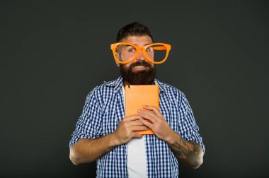 Tam bir. Ders notları ile üniversite erkek öğrenci. Ders kitabıyla parti gözlüklü sakallı adam. Kitap süslü gözlük takıyor. Çalışma nerd tutma kitap
