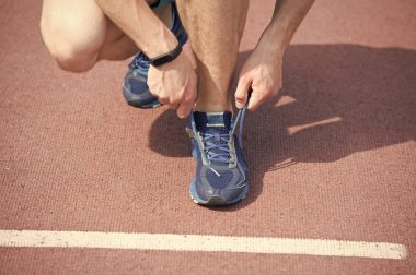Koşu için hazırlanıyor. Ayakkabı bağcığı spor ayakkabı koşu parkuru arka plan ipe eller. Ayakkabı bağcığı sportif spor ayakkabı bağlama pedometer ile sporcu elleri. Ekipman kavramı çalıştırıyor. Sıkı bağlama ayakkabı bağcığı