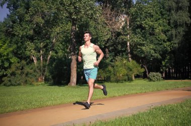 Onun en iyi hız. Adam jogger park güneşli gün doğa arka planda çalıştırabilirsiniz. Eğitim adamım, cesedini maratonu için hazır olun. Kendinizi geliştirmek için maraton popüler spor meydan okuma. Sabah dürtmek topluluğuna katılın