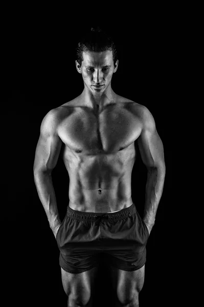 Man muscular macho posing with bare torso on black background. Guy muscular athlete put hands in pockets. Attractive macho calm face. Muscular bodybuilder keep calm. Perfect male body concept — Stock Photo, Image