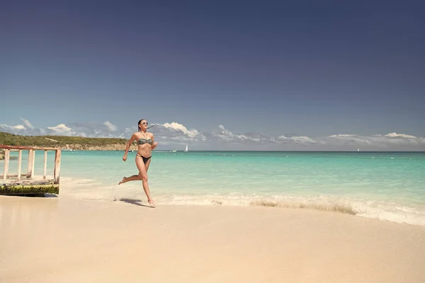 Refrescante y alegre. Chica bikini ejecutar ola azul playa del océano. Vacaciones de lujo tropical océano playa resort. Mujer sexy cuerpo relajarse océano arena blanca playa Antigua. Correr a través de la laguna mágica turquesa —  Fotos de Stock