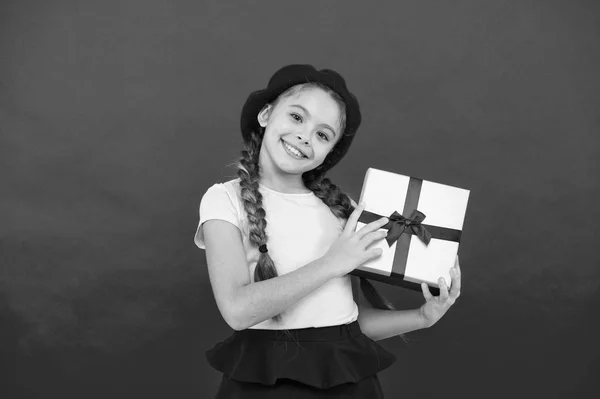 Enfant petite fille dans chapeau béret tenir boîte cadeau. Enfant excité par le déballage cadeau. Petite fille mignonne reçu paquet cadeau avec ruban arc. Devine de quoi rêve ton enfant. Les meilleurs jouets et cadeaux de Noël — Photo