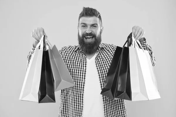 Consulta tu historial de compras. Disfruta de compras rentables ofertas negro viernes. Compras con descuento disfrutar de la compra. Hombre barbudo hipster cara alegre llevar bolsas de compras de papel sobre fondo amarillo —  Fotos de Stock