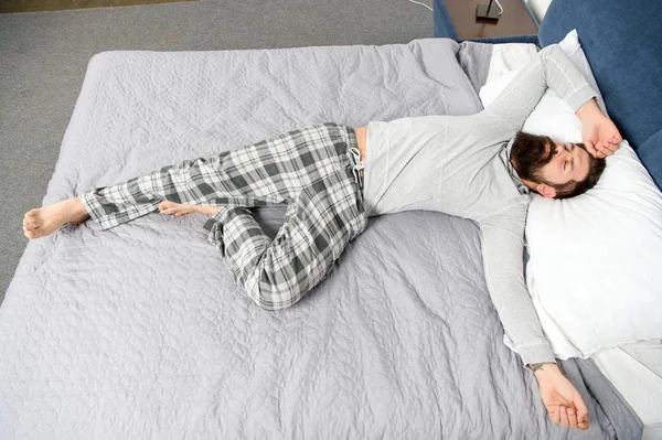 Uzun bir gece oldu. yatakta pijama sakallı olgun erkek. uykuda ve uyanık. enerji ve yorgunluk. sakallı adam hipster sabah uyku. yatak odasında acımasız uykulu adam. O dışarıda.