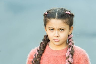 Şüpheli bir bakış. Saç örgülü pembe kanekalonlu kız. Kuaför salonu. Örülmüş şirin şey. Şirin örgüleri olan küçük bir kız. Kanekalon çocuk örgüsü. Saç stili konsepti.