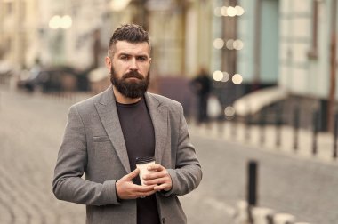 Gevşeme söz konusu. Adam hipster içki kahve kağıt bardak sakallı. İyi bakımlı işadamı kahve arası açık havada kentsel arka plan tadını çıkarın. Düşünceli ama rahat. Yürümek ve taze sıcak kahve keyfini çıkarın