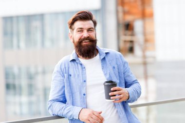 Kahve beni tamamlıyor. Bir işe yara. Adam kahveyi alıp götürüyor. Sakallı adam dışarıda rahatla. Kahve molası. Kafein bağımlısı. Sabah kahvesi. Olgun hipster sıcak içeceğin tadını çıkar.