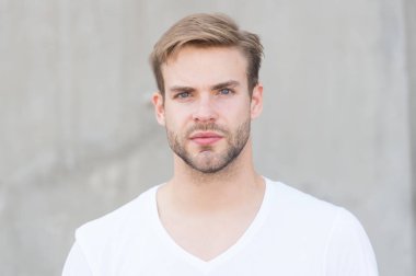 Yakışıklı beyaz adam gri arka plan. Sakallı adam rahat tarzı yakın. Erkek güzellik standartları. İnsanı fiziksel olarak çekici yapan ideal özellikler. Yakışıklı adam traşsız yüz şık saç modeli