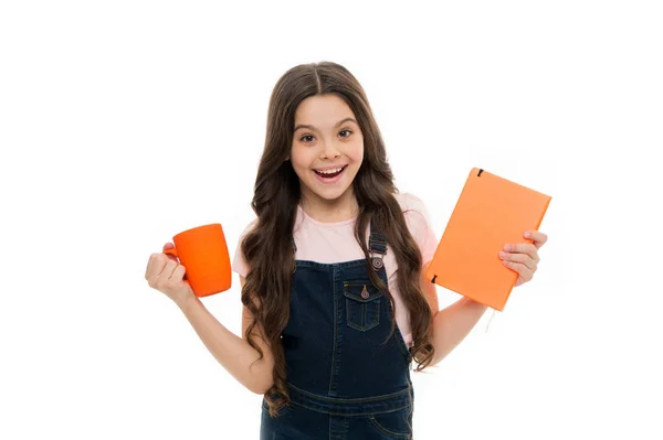 Comience el día con el desayuno. Niña disfrutando su desayuno escolar. Niño bebiendo té o leche para el desayuno. Niño de la escuela desayunando por la mañana. Linda colegiala sosteniendo taza y libro — Foto de Stock