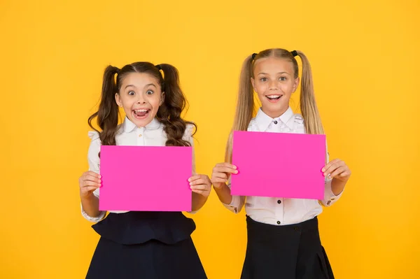 Conceito de comunicação visual. Amizade escolar. Meninas uniforme escolar segurar cartaz. As raparigas da escola mostram cartaz. Espaço de cópia de cartaz social. Socialização envolve como as crianças se dão bem umas com as outras — Fotografia de Stock